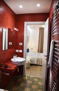 uma casa de banho com um lavatório e uma cama num quarto em Dimorae houses em Caltanissetta