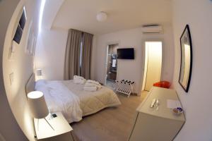 カルタニッセッタにあるDimorae housesのベッド1台とテーブル2台が備わるホテルルームです。