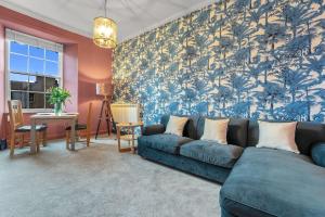 sala de estar con sofá azul y mesa en Boutique Modern Royal Mile Apartment Sleeps 4, en Edimburgo