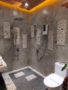a bathroom with a shower and a toilet at Mingalar Boutique Hotel in Kawthaung