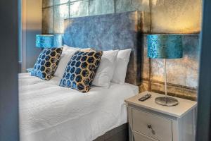 1 dormitorio con 1 cama con 2 lámparas en una mesita de noche en Boutique Modern Royal Mile Apartment Sleeps 4, en Edimburgo