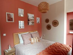 een slaapkamer met een bed met oranje muren bij Le Cocon du Lisey, le joyau du vieux Cauterets in Cauterets