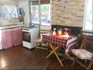 a kitchen with a table and a stove top oven at Cabaña Tía Sonia in San José de Mayo