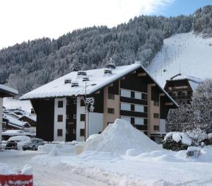 a ski lodge with a pile of snow in front of it at Chevruls A14 in Morzine