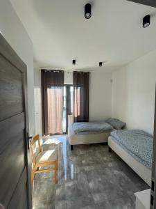 - une chambre avec deux lits, une chaise et une table dans l'établissement U Adama i Ewy, à Gąski