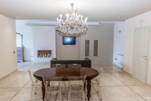 una sala da pranzo con tavolo, sedie e lampadario di Residenza Borgo degli Ulivi a Vasto