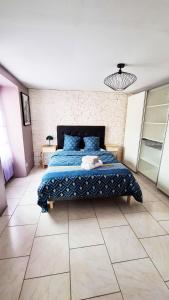 Schlafzimmer mit einem Bett mit blauer Decke in der Unterkunft Maison de 3 chambres avec terrasse et wifi a Saint Michel sur Orge in Saint-Michel-sur-Orge