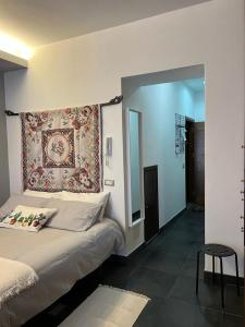 a bedroom with a bed with a tapestry on the wall at Casa Roberto in Cefalù