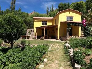 a yellow house with a garden in front of it at La Amarilla, casa con hermosa vista in Tilcara