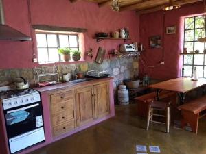 a kitchen with a stove and a table in it at La Amarilla, casa con hermosa vista in Tilcara