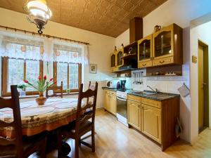 a kitchen with a wooden table and a dining room at Holiday Home Zlata Olesnice by Interhome in Zlatá Olešnice