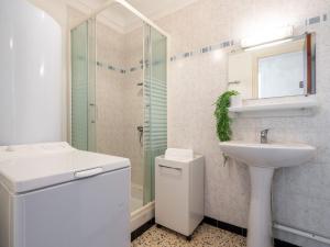 een witte badkamer met een wastafel en een douche bij Apartment Etoile de Mer by Interhome in Canet-en-Roussillon