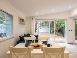 una sala de estar con una mesa y sillas en Chalet Cottage Etoile de mer by Interhome, en Lacanau