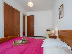 een slaapkamer met een groot bed en een roze deken bij Apartment Etoile de Mer by Interhome in Canet-en-Roussillon