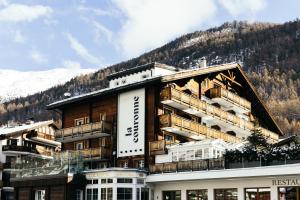 un grand bâtiment avec une montagne en arrière-plan dans l'établissement la couronne Hotel & Spa, à Zermatt