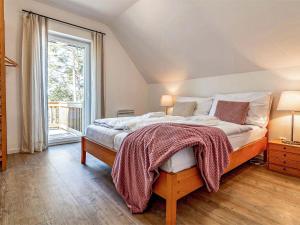 a bedroom with a large bed and a window at Holiday Home Lakeside Village 11 by Interhome in Frymburk