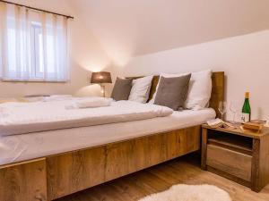 sypialnia z dużym drewnianym łóżkiem z białą pościelą i poduszkami w obiekcie Holiday Home Lakeside Village 11 by Interhome w mieście Frymburk