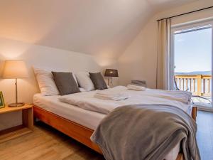 a bedroom with a large bed with a window at Holiday Home Lakeside Village 11 by Interhome in Frymburk