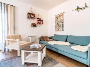 a living room with a blue couch and a table at Holiday Home Lakeside Village 11 by Interhome in Frymburk
