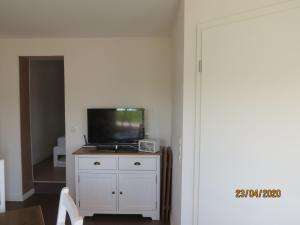 a living room with a tv on a white cabinet at Ferienhaus an der Sternwarte in Rudolstadt