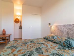 una camera da letto con un letto con un piumone colorato di Apartment Hibiscus by Interhome a Le Rayol-Canadel-sur-Mer