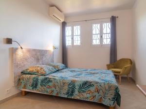 a bedroom with a bed and a chair and a window at Apartment Hibiscus by Interhome in Rayol-Canadel-sur-Mer