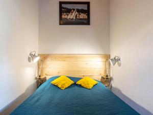 a bedroom with a blue bed with two yellow pillows at Holiday Home Les Maisons de l'Océan-1 by Interhome in Les Mathes