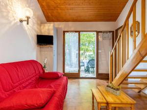 a living room with a red couch and a table at Holiday Home Les Maisons de l'Océan-1 by Interhome in Les Mathes +13 photos