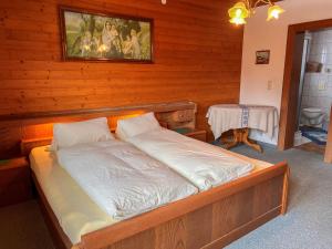 ein Schlafzimmer mit einem Bett in einem Holzzimmer in der Unterkunft Apartment App-1 by Interhome in Hollersbach im Pinzgau