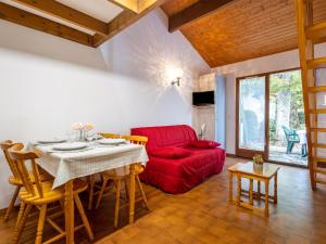 a living room with a table and a red couch at Holiday Home Les Maisons de l'Océan-1 by Interhome in Les Mathes