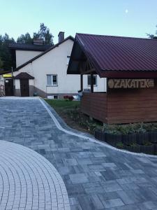 um edifício com um telhado vermelho e uma entrada de tijolos em Zakątek em Wysowa-Zdrój