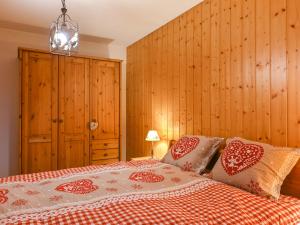 sypialnia z łóżkiem z białymi i czerwonymi poduszkami w obiekcie Apartment Plein Sud by Interhome w mieście Ovronnaz