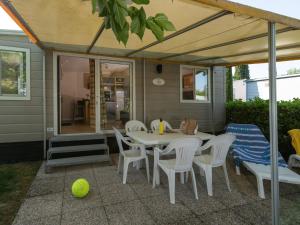 a patio with a table and chairs and a tennis ball at Holiday Home San Francesco Camping Village by Interhome in Rivoltella