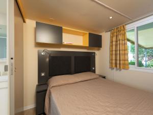 a bedroom with a bed and a window at Holiday Home San Francesco Camping Village by Interhome in Rivoltella