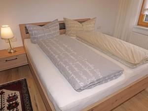 a bed with two blankets and pillows on it at Apartment Schlatter by Interhome in Alterzoll