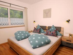 a bedroom with a bed with pillows on it at Apartment Haus Stock by Interhome in Tux