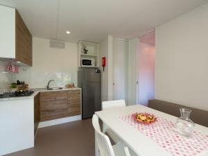 a kitchen with a white table and a refrigerator at Holiday Home Garda Suite Deluxe by Interhome in Rivoltella