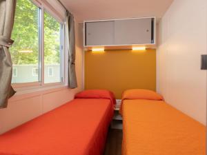 dwa łóżka w pokoju z oknem w obiekcie Holiday Home San Francesco Camping Village by Interhome w mieście Rivoltella del Garda