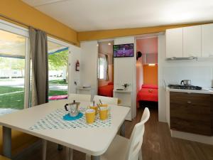 a kitchen and living room with a white table and chairs at Holiday Home Garda Family Plus by Interhome in Rivoltella
