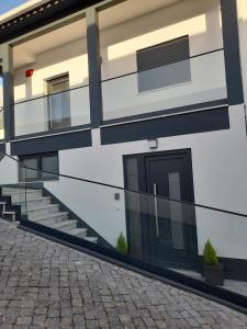 a building with a door on the side of it at Hall 92 Quartos com WC em moradia com piscina A-das-Lebres Loures in Loures