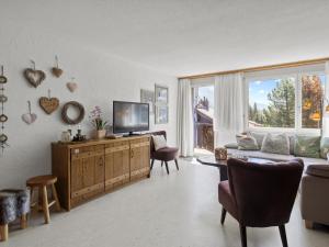 a living room with a couch and a tv at Apartment A302 by Interhome in Lenzerheide