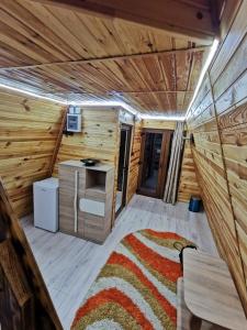 a cabin with a rug in the middle of a room at Căbănuța La Gălățanu in Vulcan