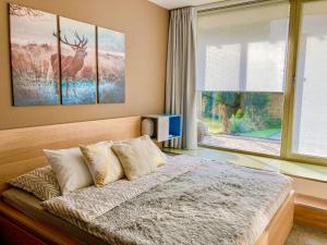 ein Schlafzimmer mit einem Bett und einem großen Fenster in der Unterkunft Studio Čertovka U jelena by Interhome in Harrachov