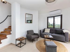 a living room with a couch and a chair at Holiday Home Nimes by Interhome in Calonge +18 photos