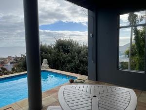 a view of a swimming pool from a house at Behrs Lair Luxury Villa Simons Town in Cape Town