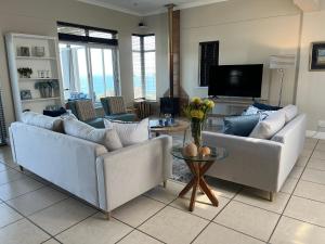 a living room with two couches and a tv at Behrs Lair Luxury Villa Simons Town in Cape Town