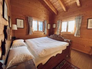 a bedroom with a bed in a log cabin at Chalet Chalet Rodas 9 by Interhome in Malmigiuer