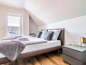 a bedroom with a large bed and a window at Holiday Home Lakeside Village 40 by Interhome in Frymburk