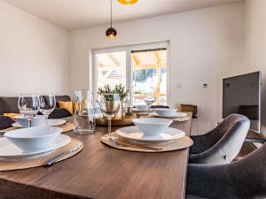 a dining room table with plates and glasses on it at Holiday Home Lakeside Village 40 by Interhome in Frymburk
