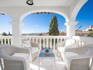 un patio con sedie bianche e un tavolo sul balcone. di Villa Mara by Interhome a Caleta de Velez